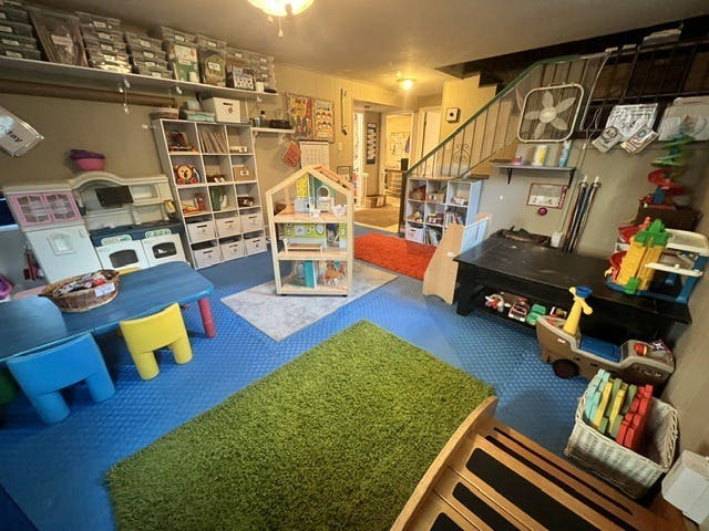 Playroom with children toys furniture and organizers on a blue foam floor