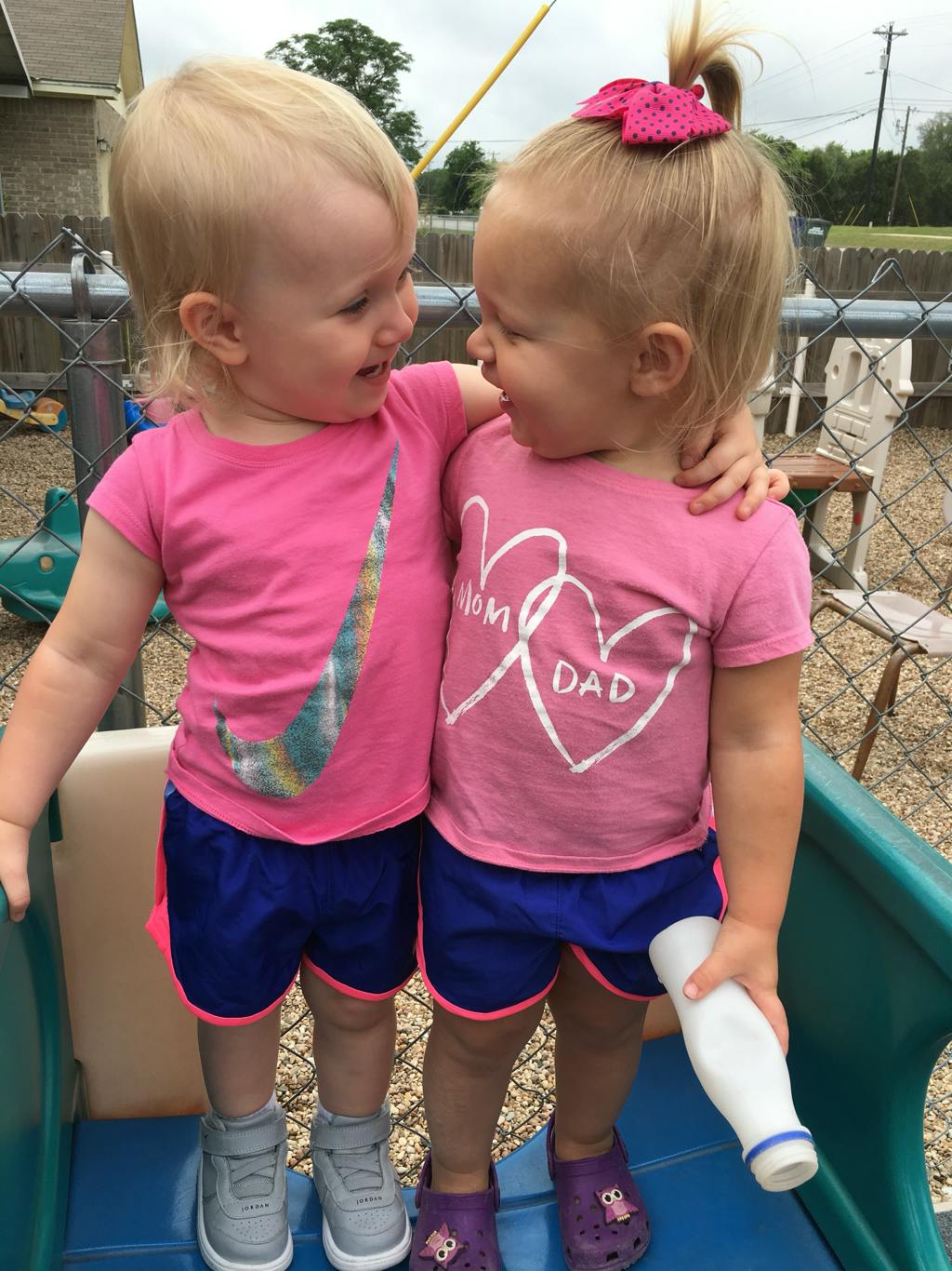 Two children in pink shirts embracing