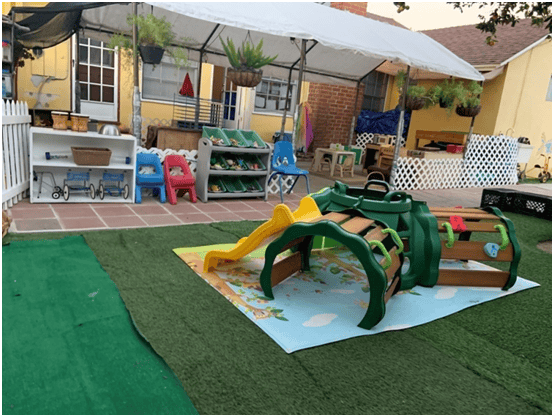 Outdoor play area with a green and yellow slide and climbing structure