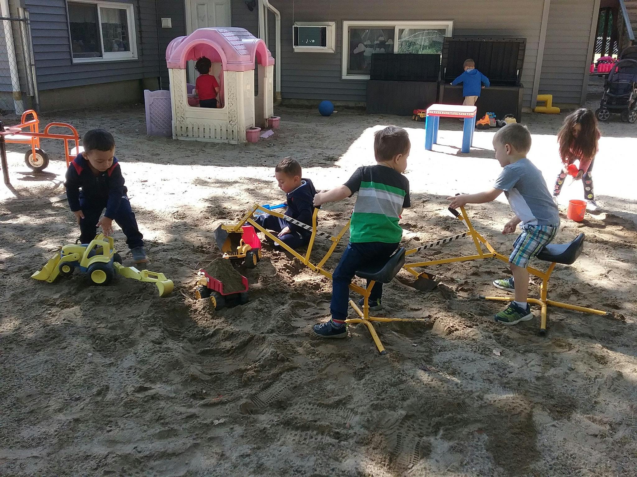 Children playing with sand diggers in a sandbox
