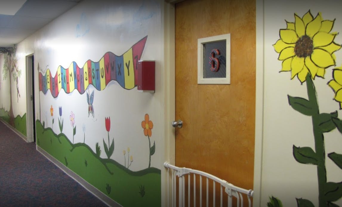 Hallway with colorful wall murals and a door with the number 6