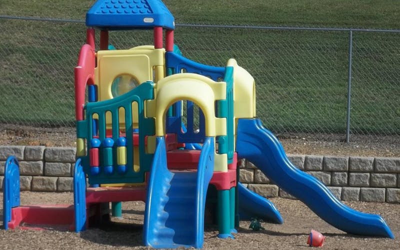 Colorful playground structure with slides and climbing areas on wood chips
