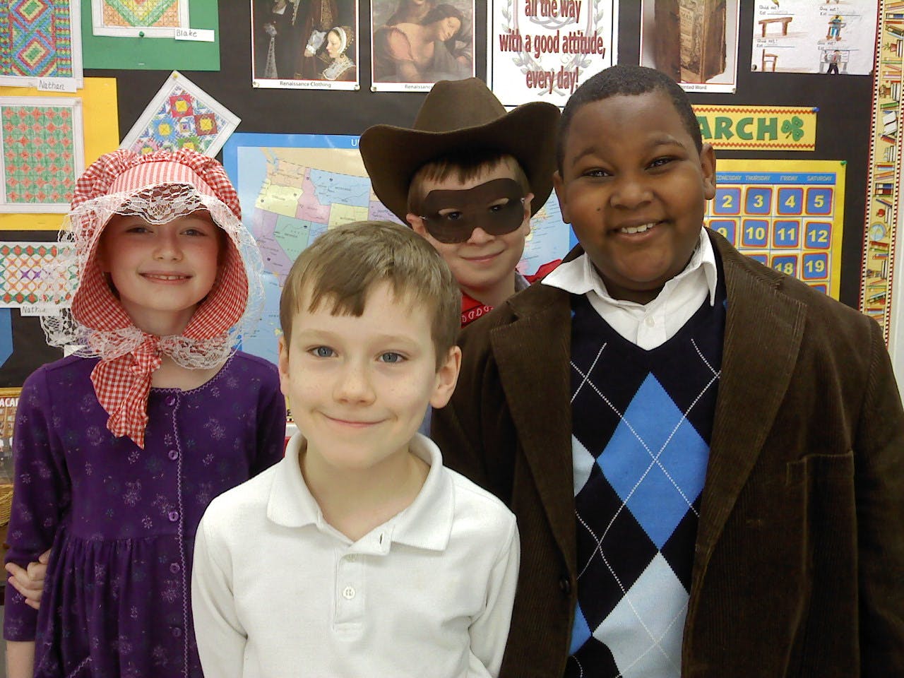 Four children in costumes, one in a bonnet, one in a cowboy hat and mask