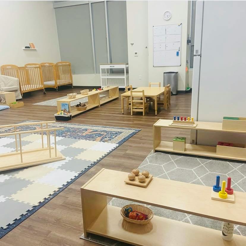 Childcare room interior with cribs and low shelving for educational toys