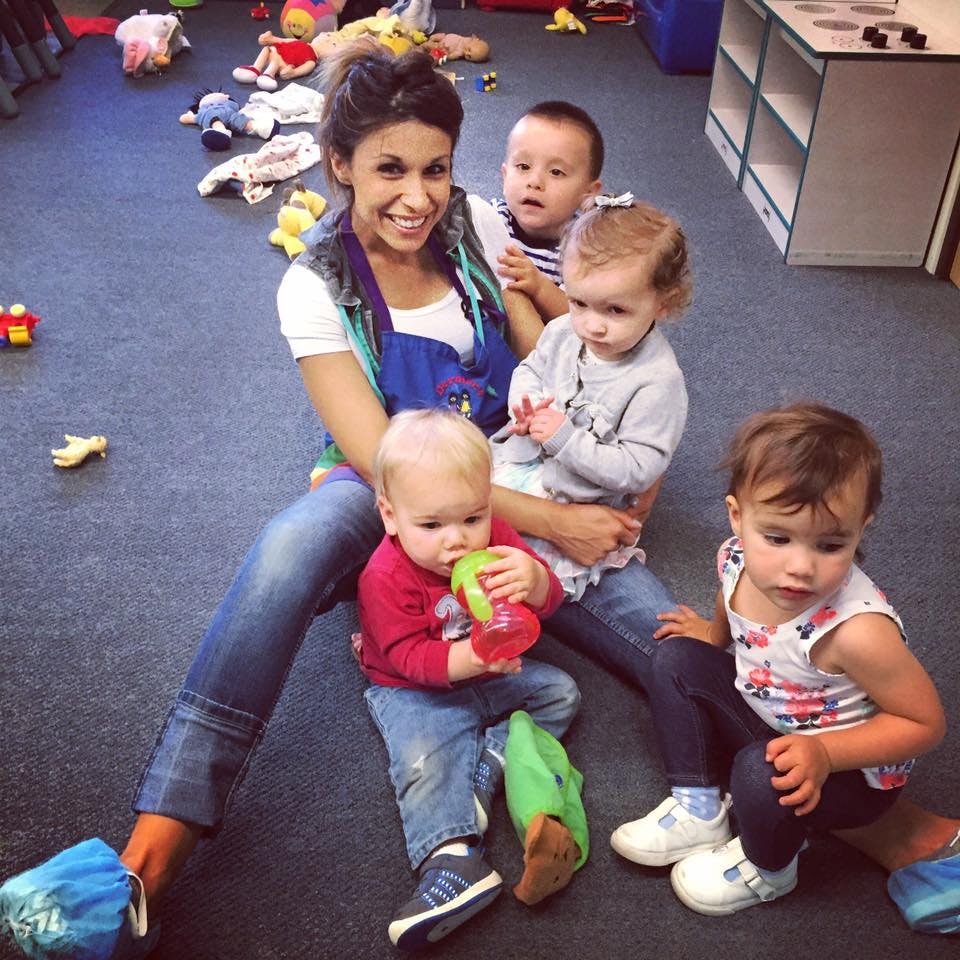 Person sitting on floor with four children
