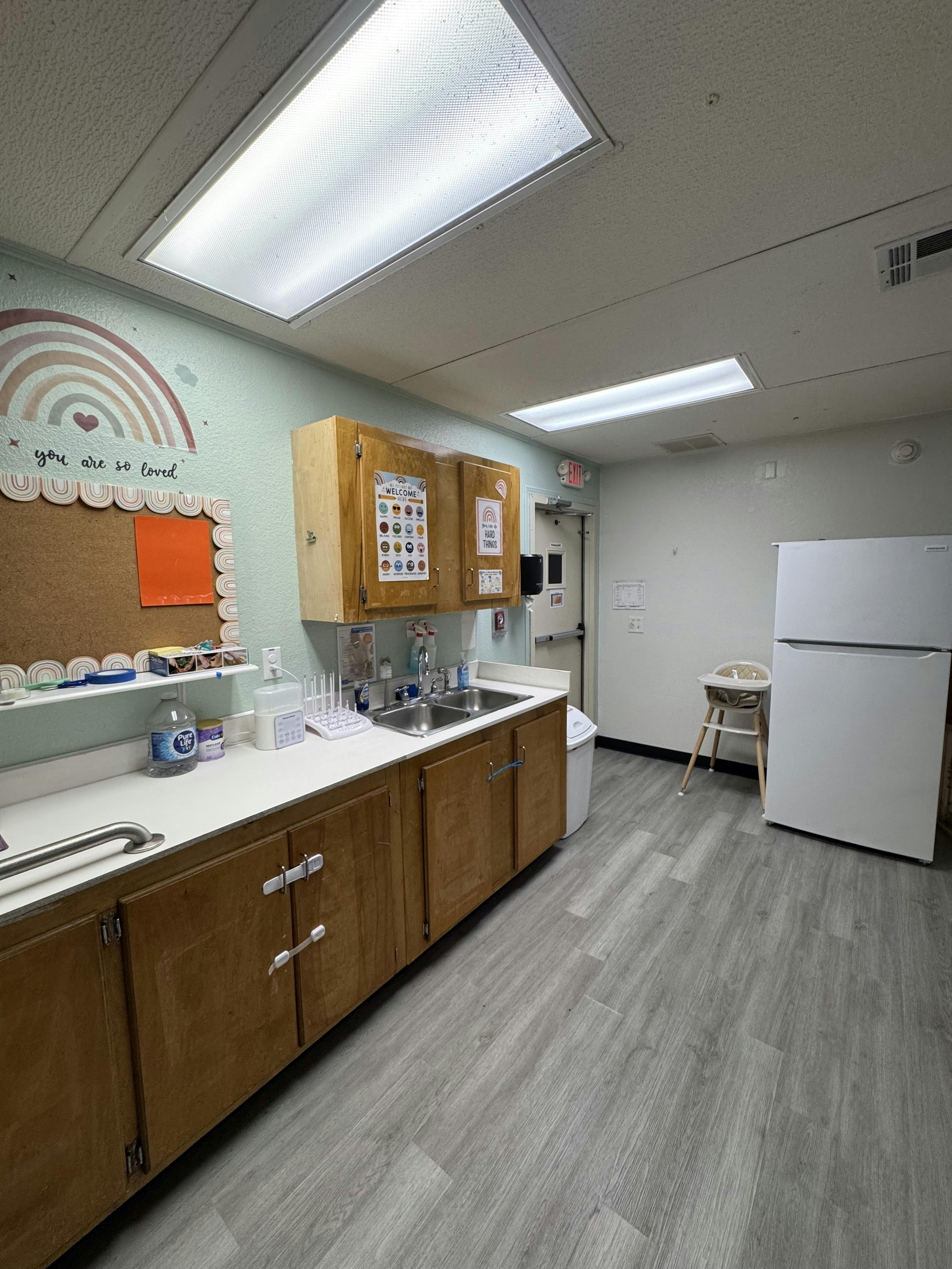 Kitchenette with sink, wooden cabinets, and white refrigerator