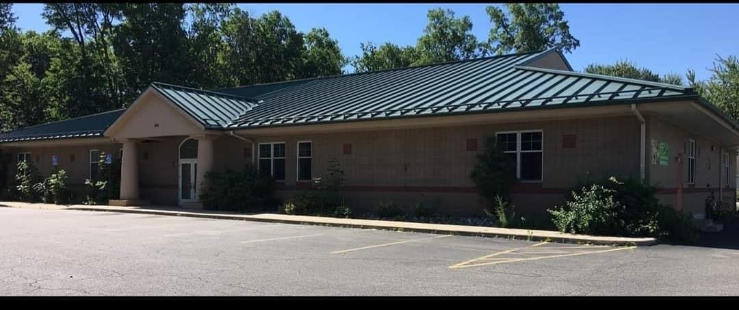Building with a green roof and a parking lot in front