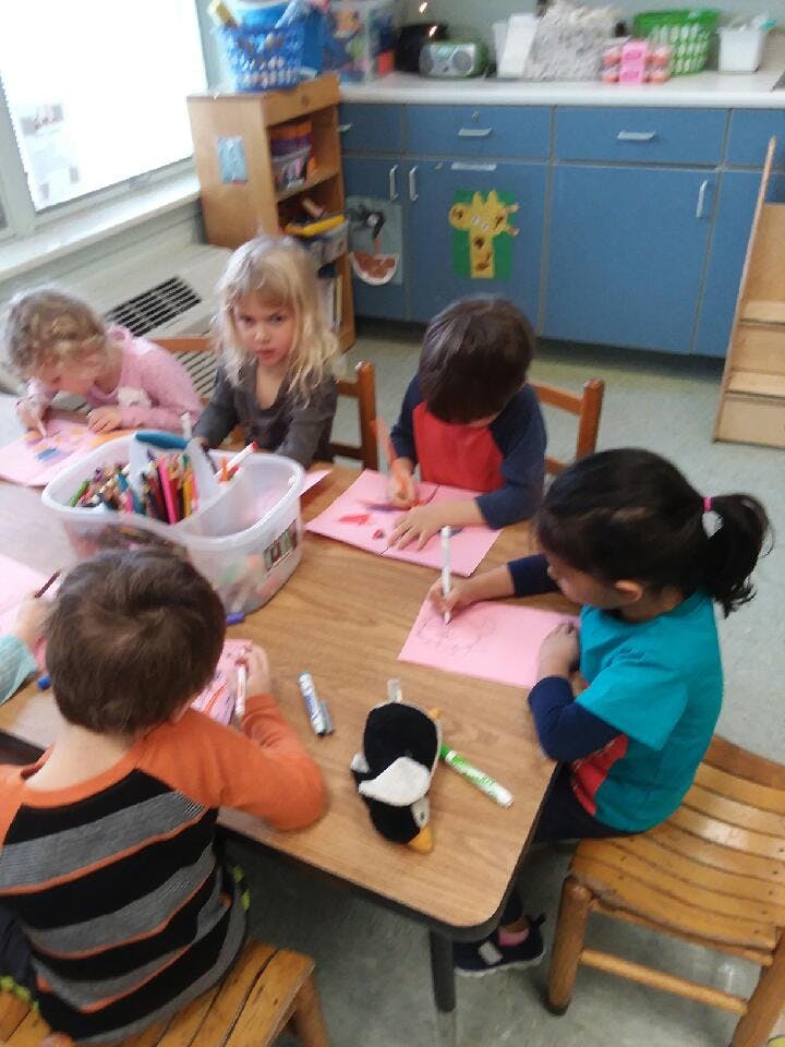 Children drawing at a table in a classroom