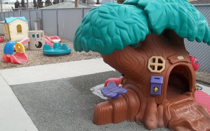 Plastic outdoor playground equipment shaped like a treehouse and other structures