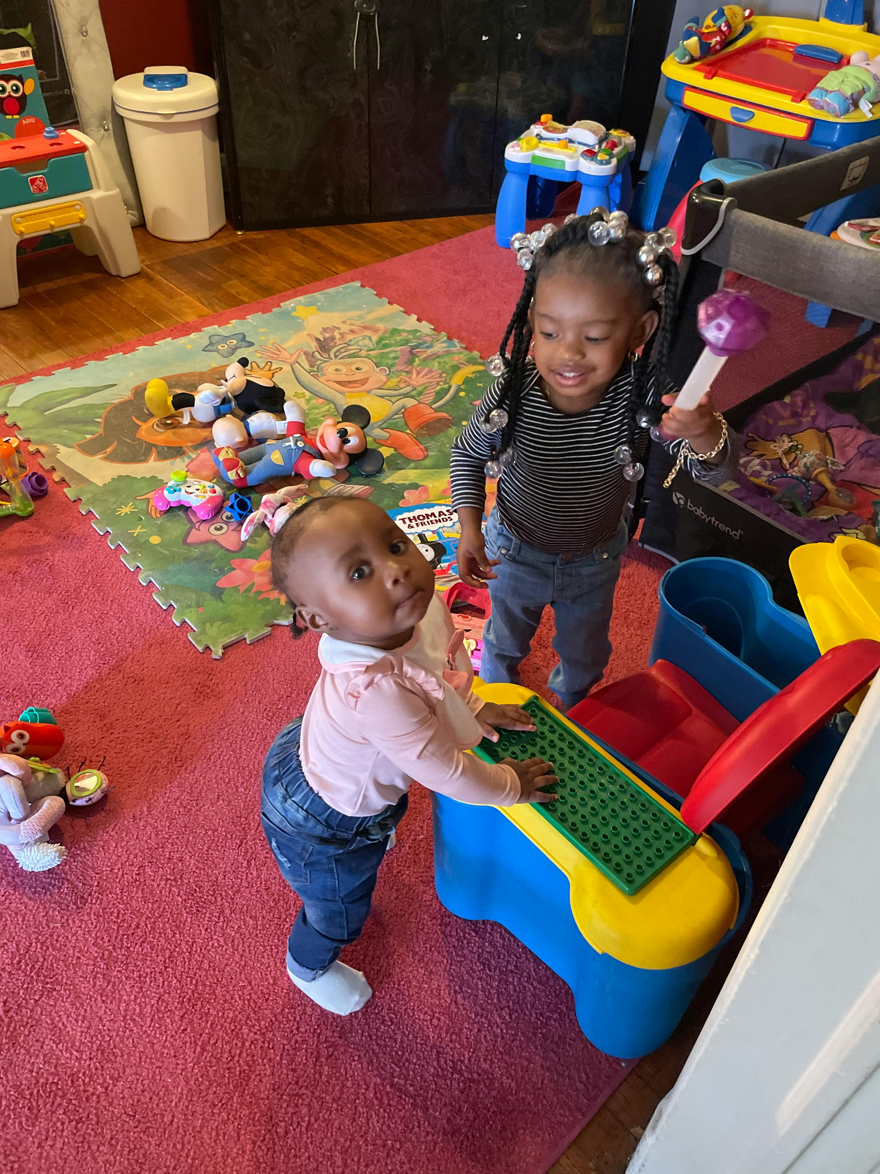 Two children playing with toys in a room