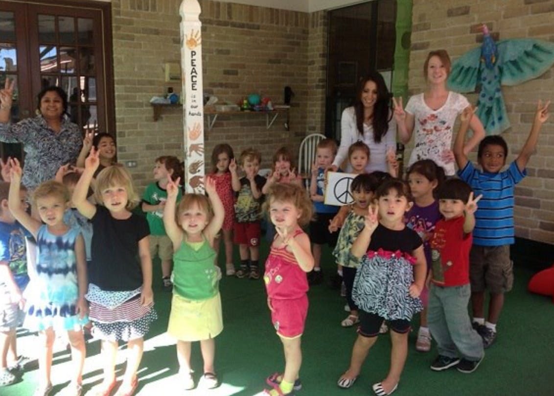 Group of children and adults making peace signs