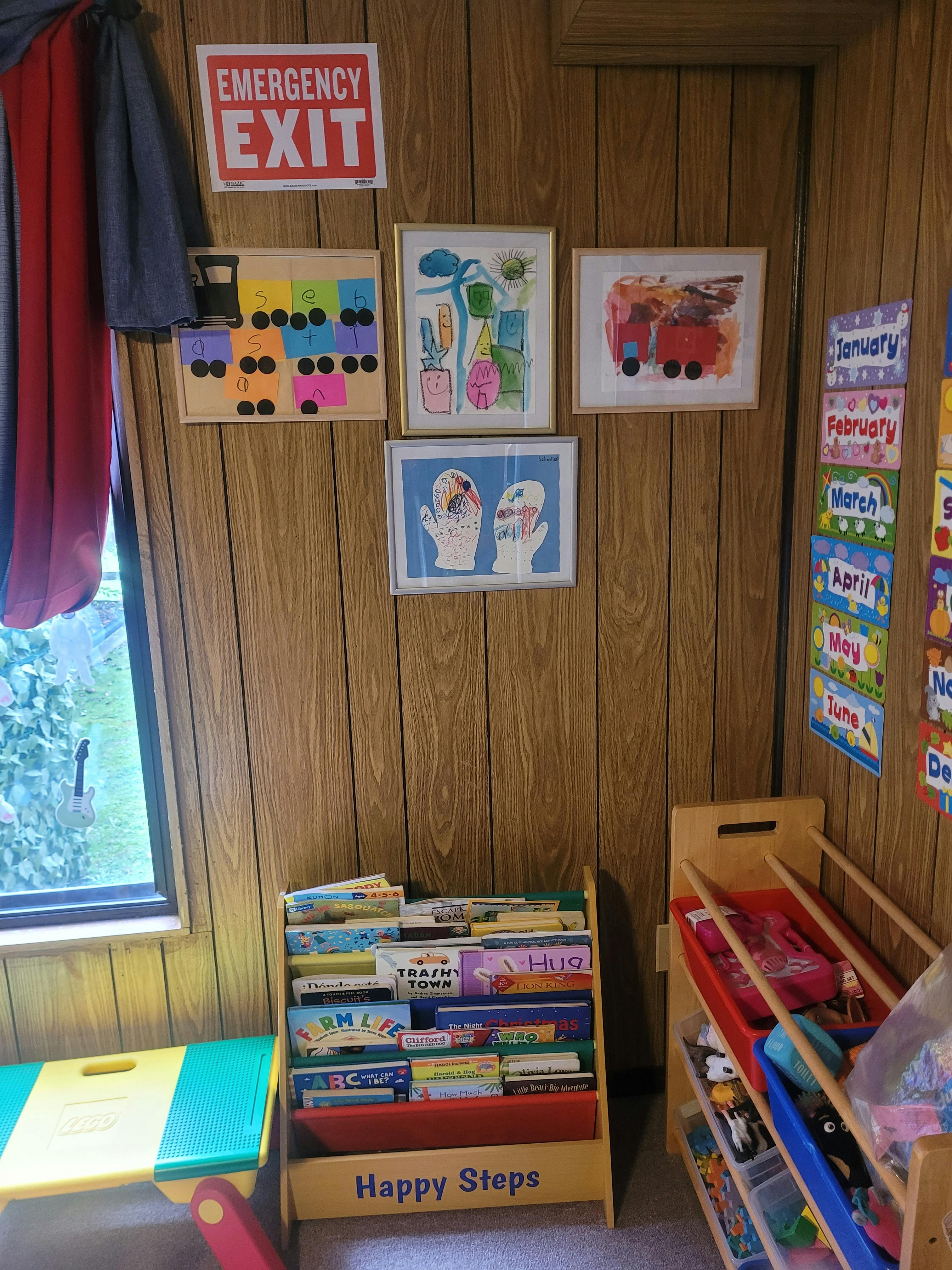 Emergency Exit sign above children's artwork and bookshelves
