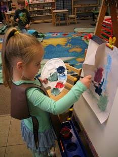 Child painting at an easel