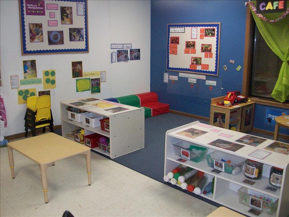 Classroom with shelves, small tables, and bulletin boards