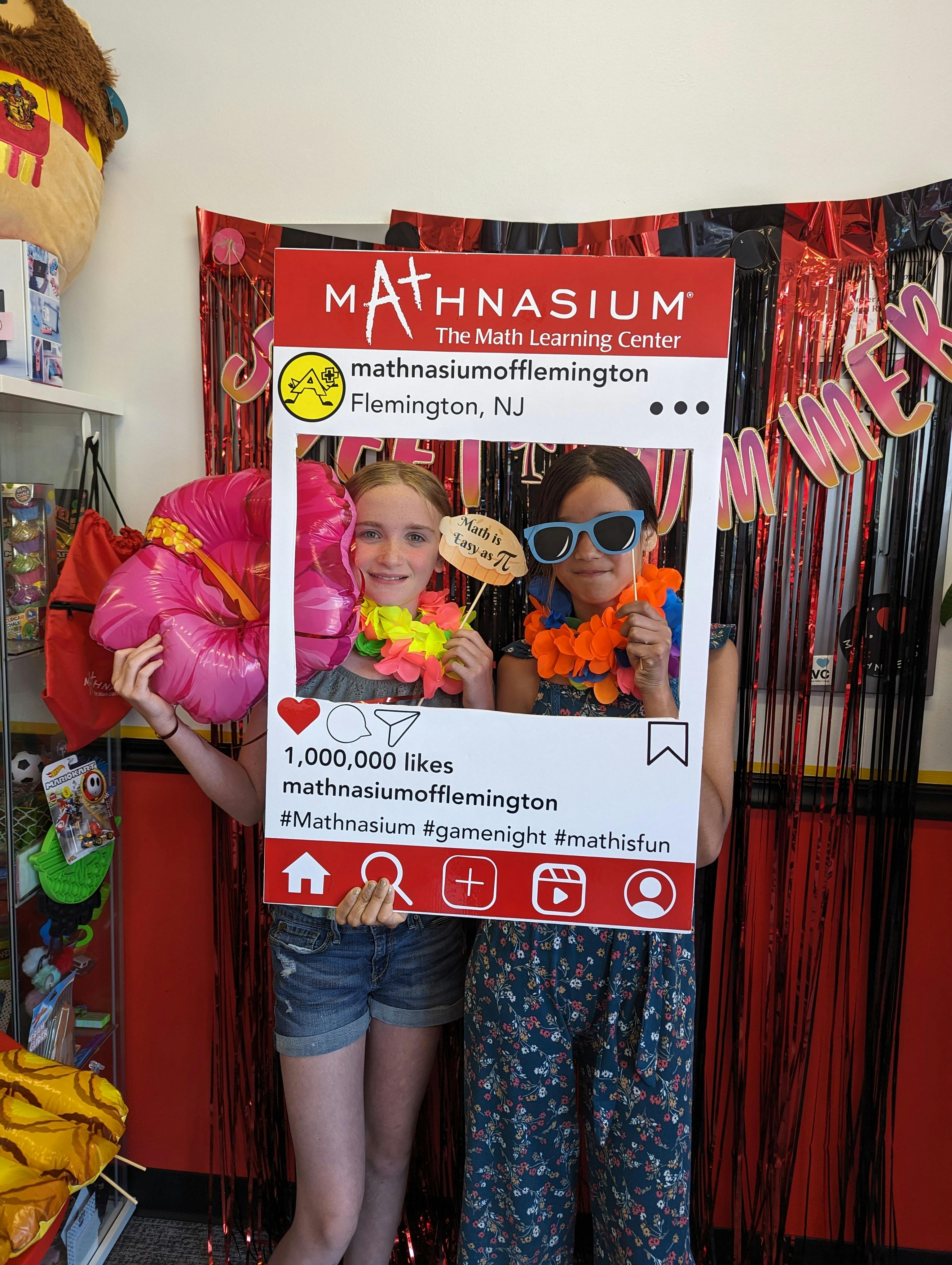 Two children posing with a Mathnasium social media frame