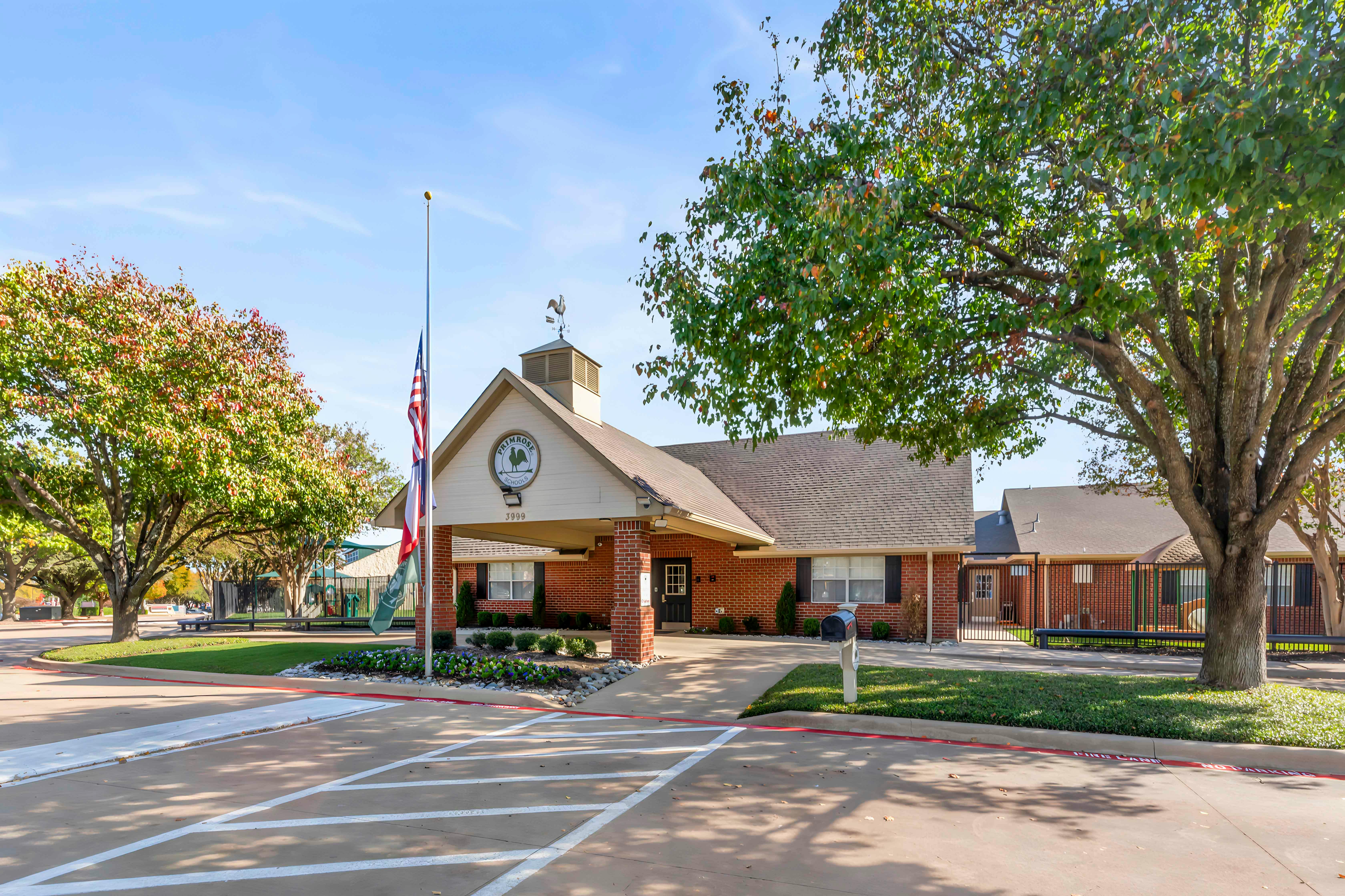 Primrose School building exterior with a brick facade and flag pole