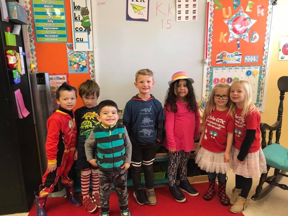 Seven children standing in a classroom