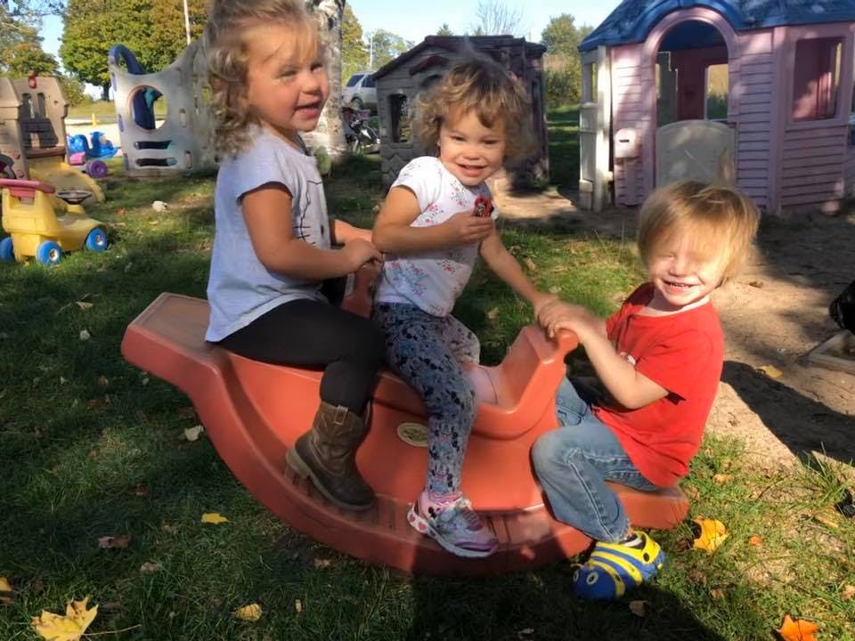 Three children on a seesaw in a playground