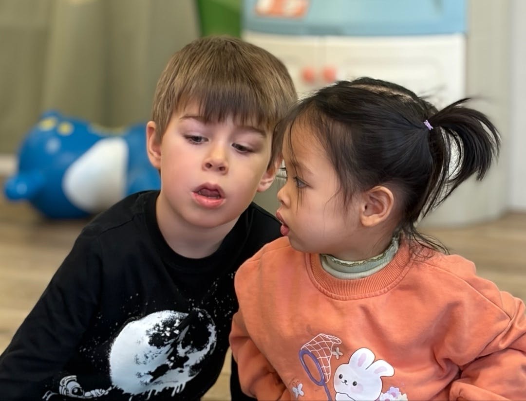 Two children looking at each other in a playroom