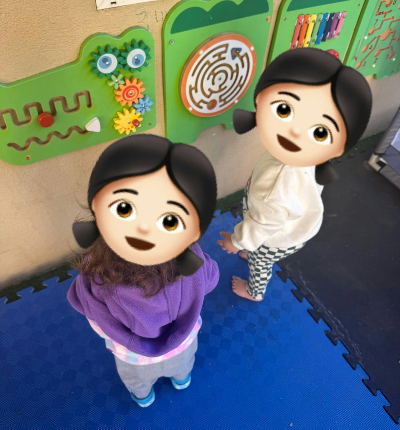 Two children playing with wall-mounted activity boards