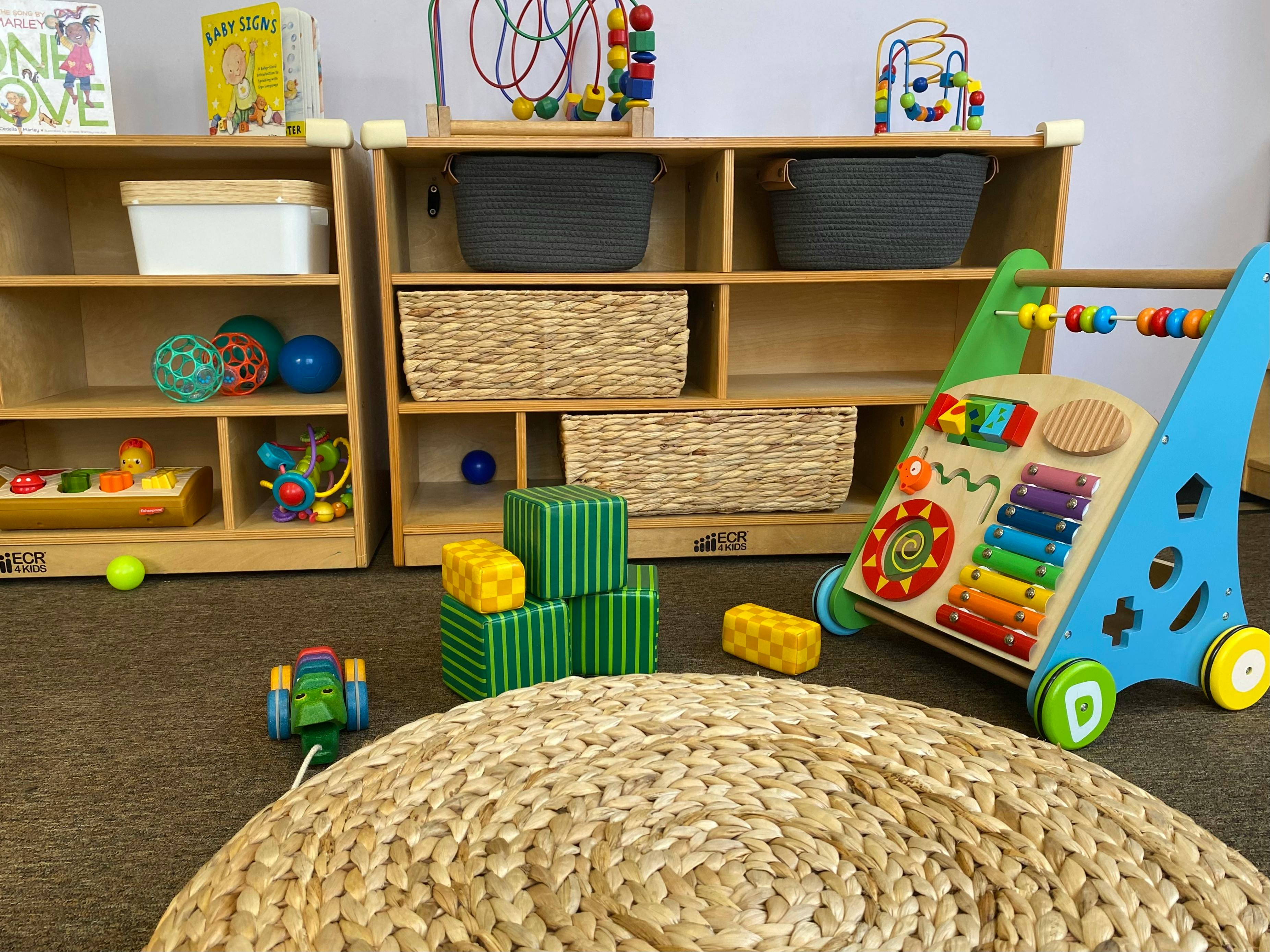 Child's play area with wooden shelves, baskets, and various toys