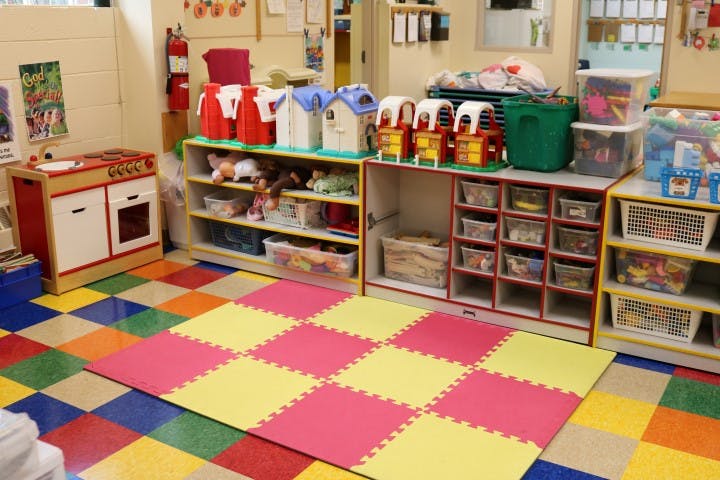 Playroom with colorful floor tiles and shelves of toys