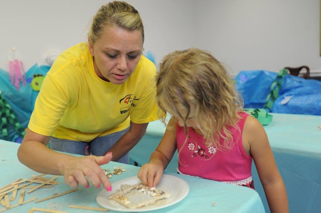 Person and child making crafts with popsicle sticks