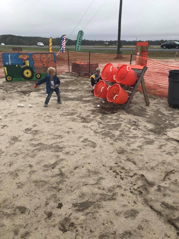 Child playing a game with buckets and balls outdoors