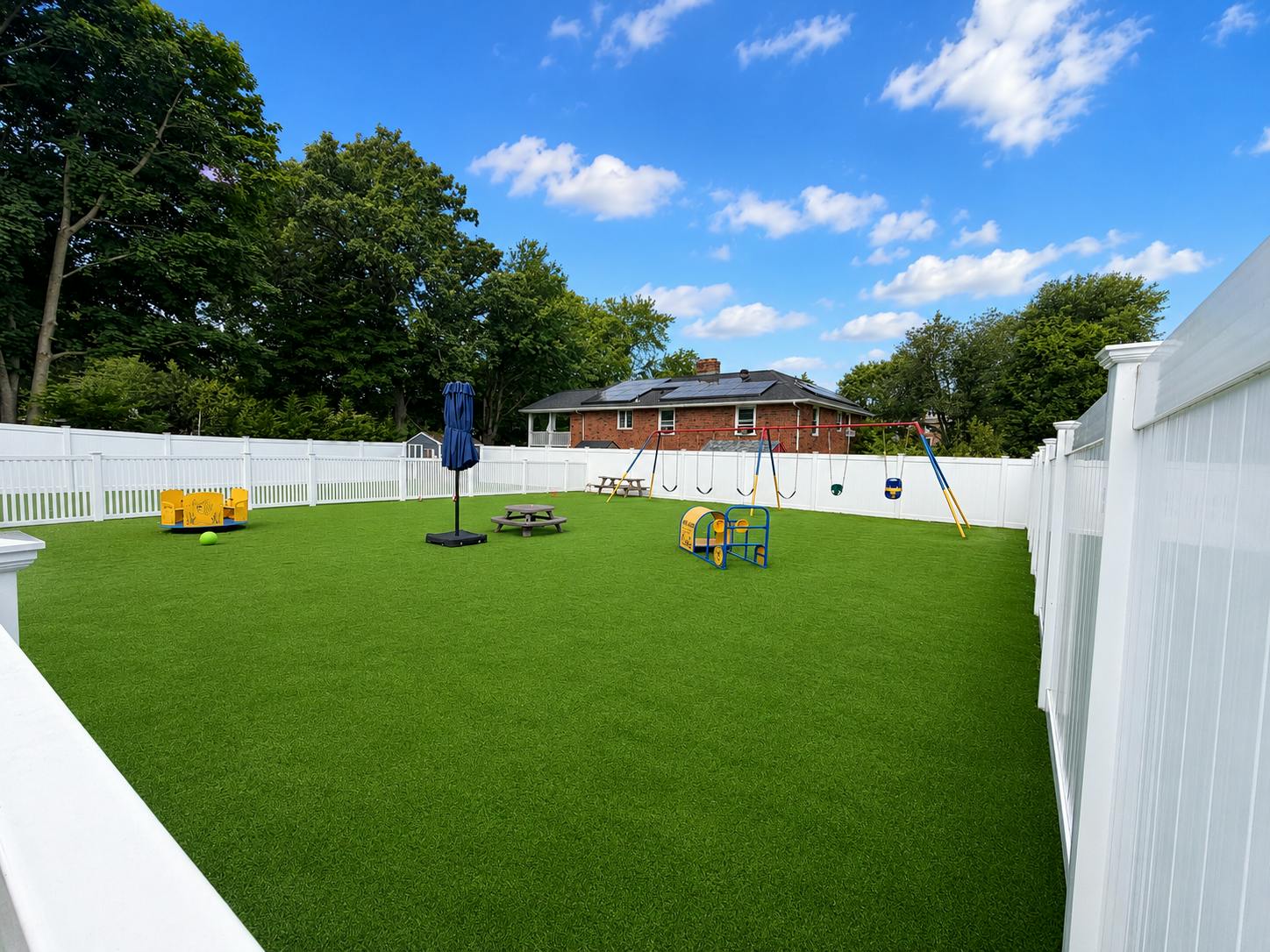 Backyard playground with artificial turf swings and small play equipment