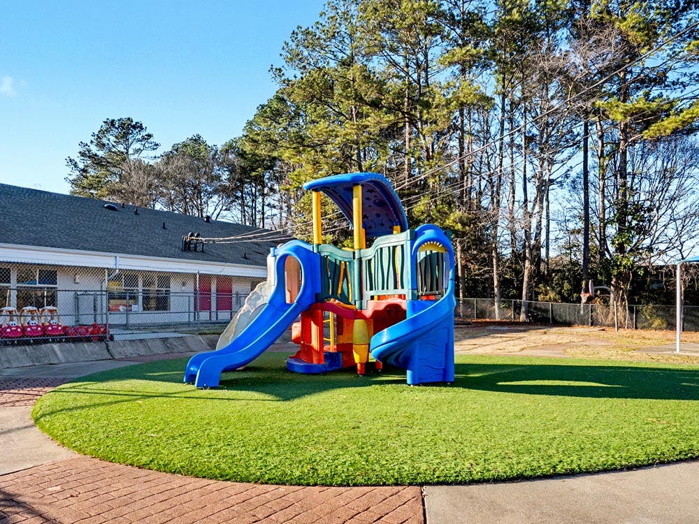 Colorful playground structure with slides on artificial grass