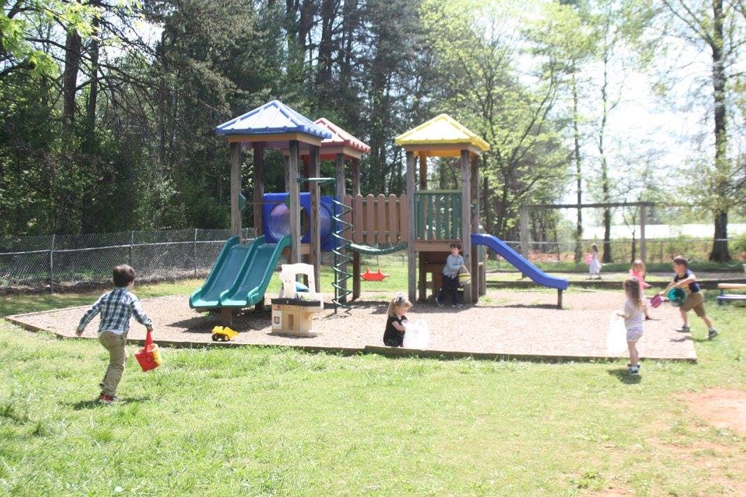 Children playing on a playground with slides and play structures