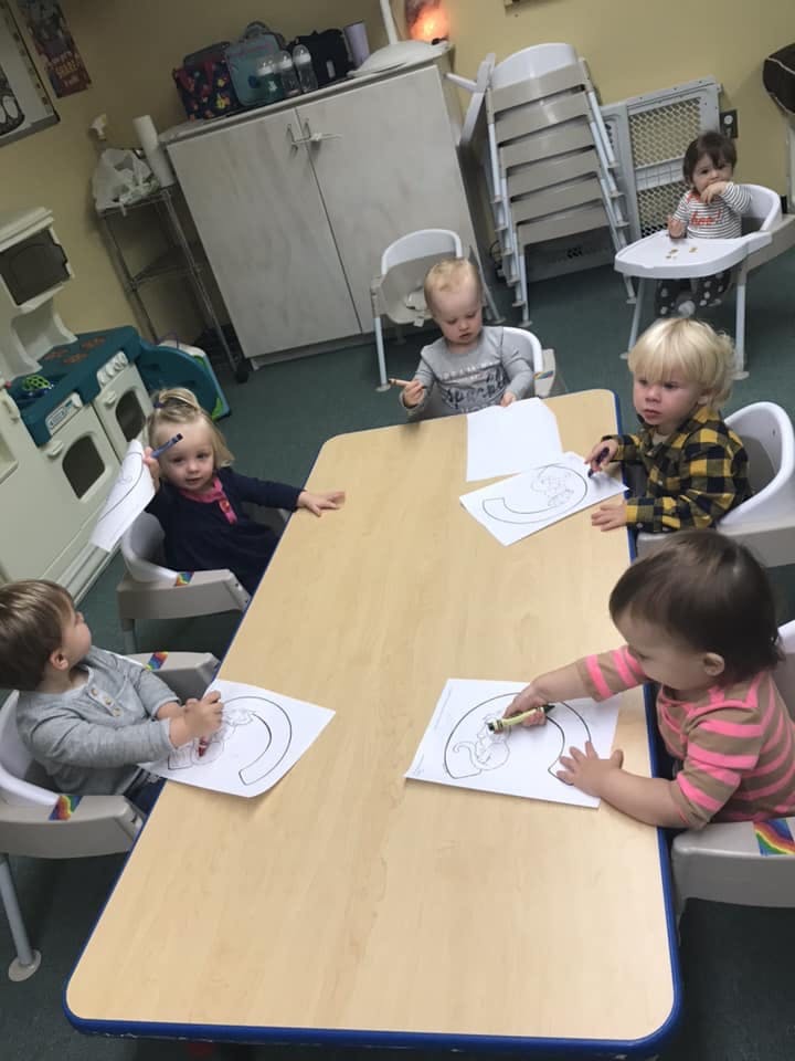 Children sitting at a table coloring