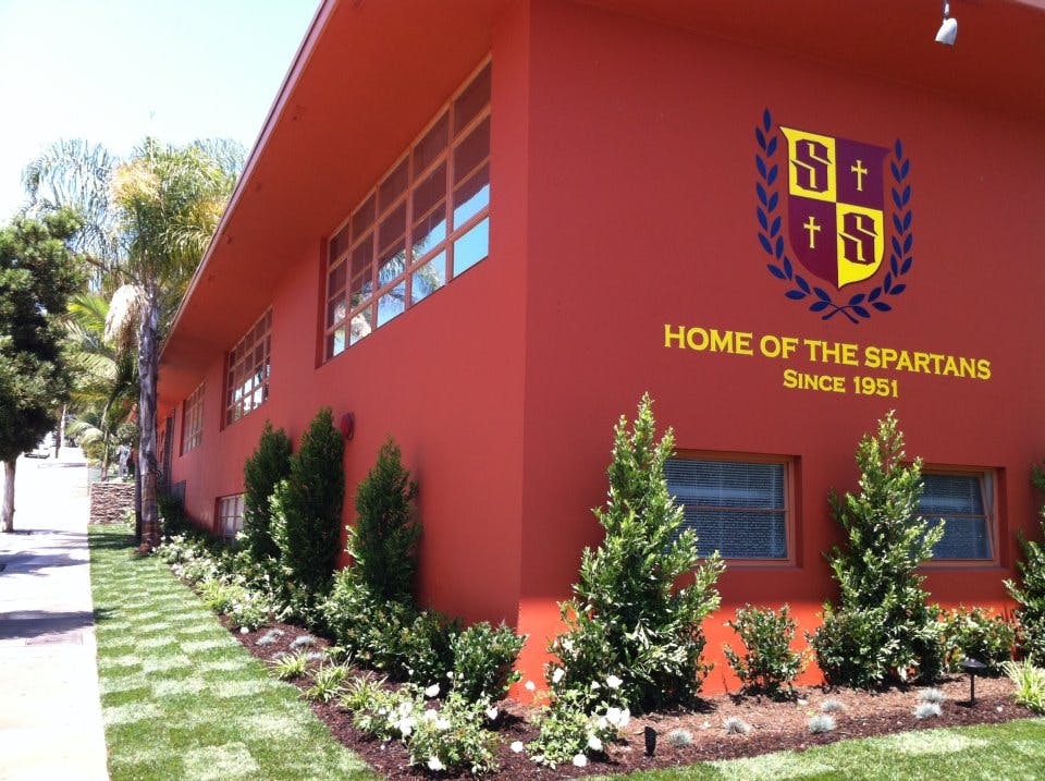 Building exterior with school crest and text "Home of the Spartans Since 1951"