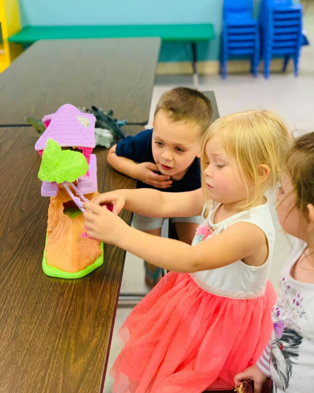 Children playing with a toy house on a table
