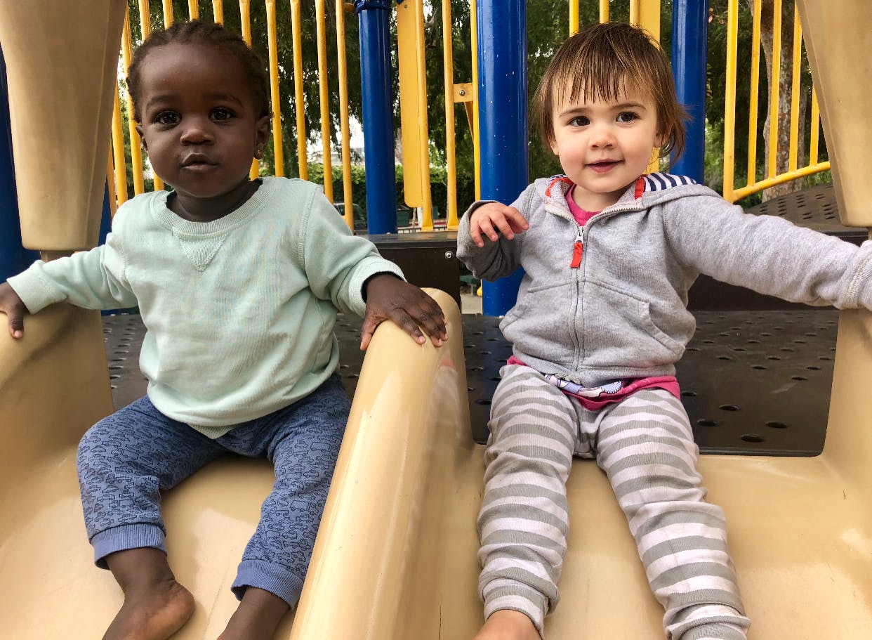 Two children sitting on a playground slide