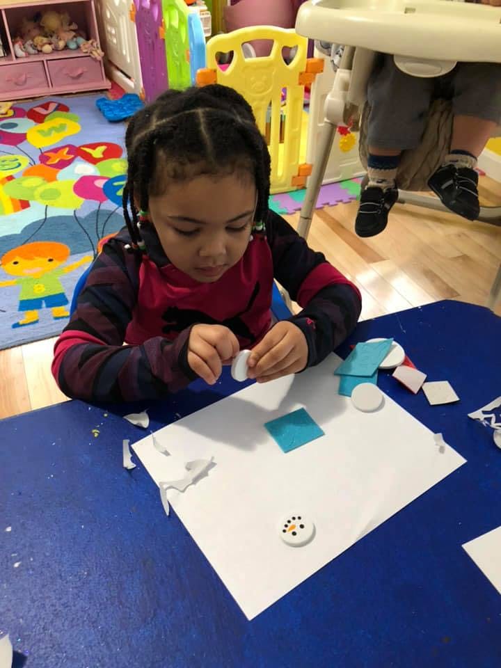 Child making a craft at a table