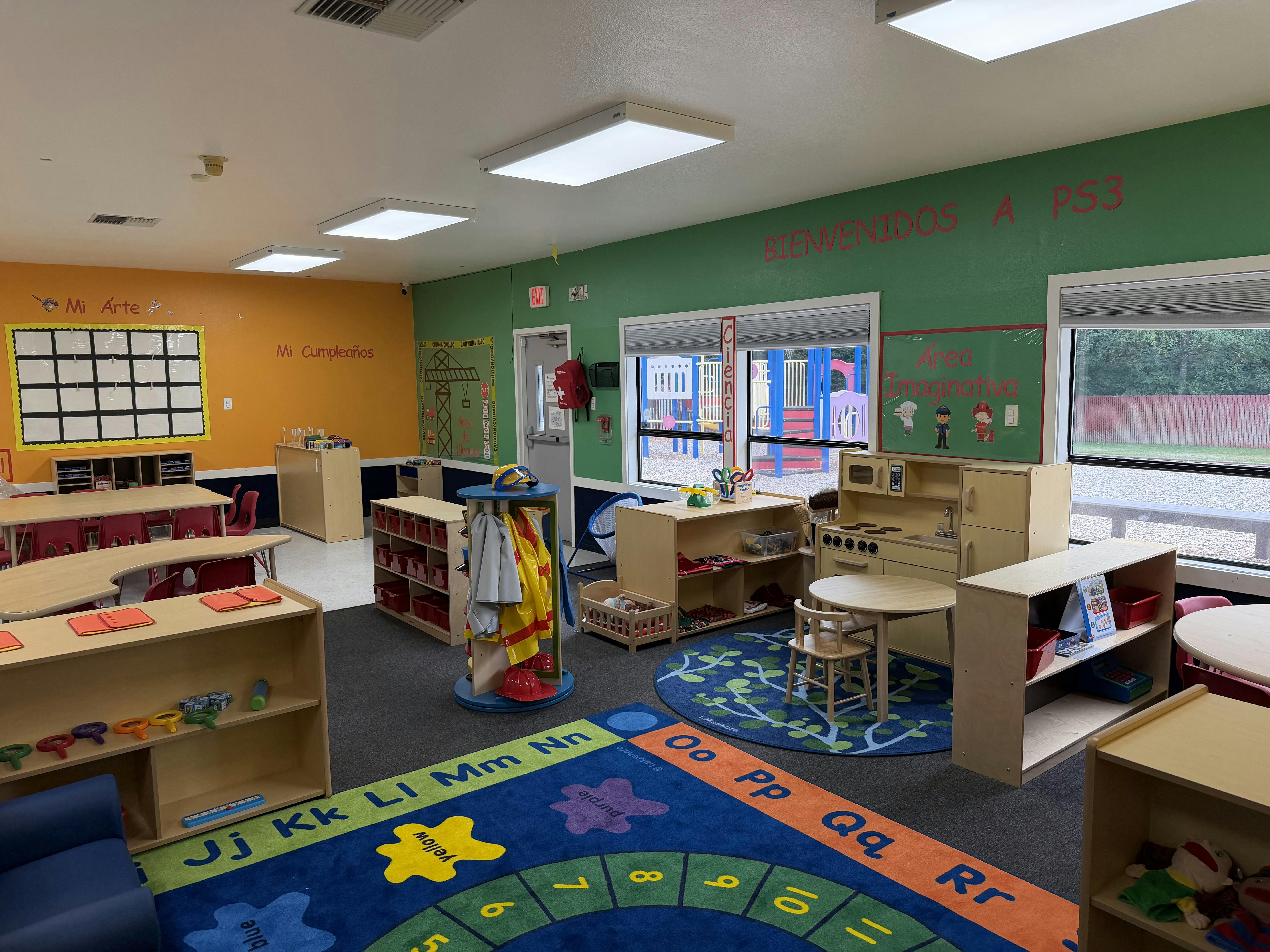 Colorful preschool classroom interior with educational rugs and learning stations