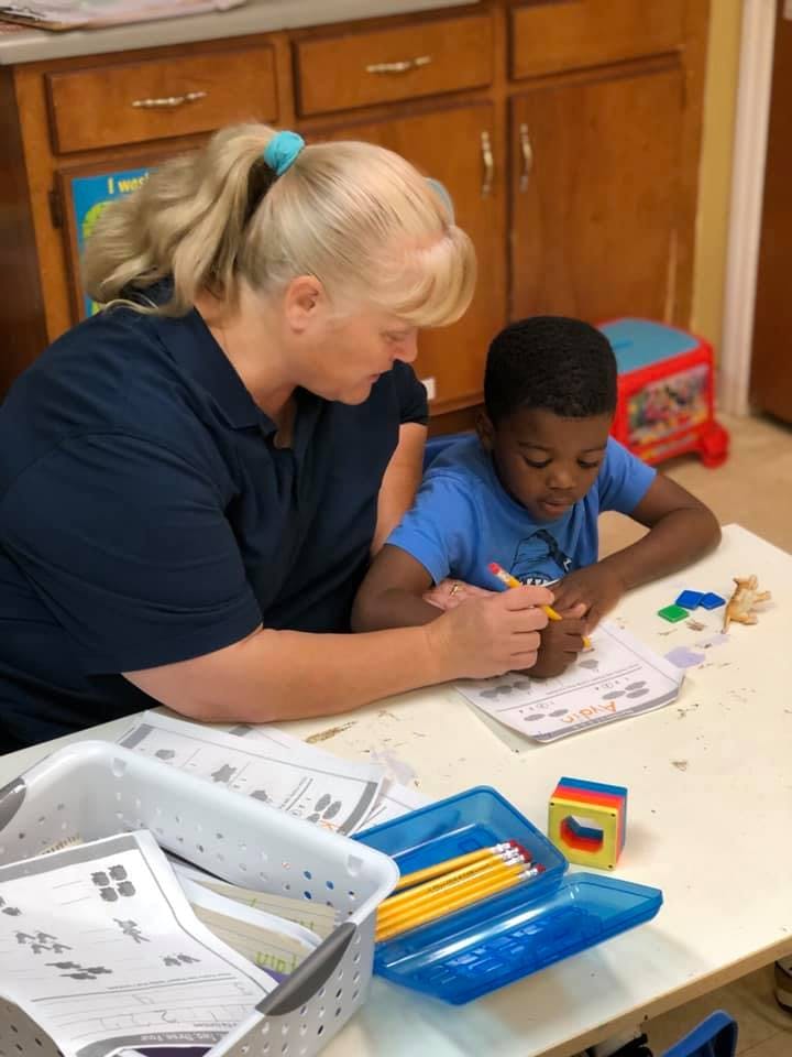 Adult and child writing at a table