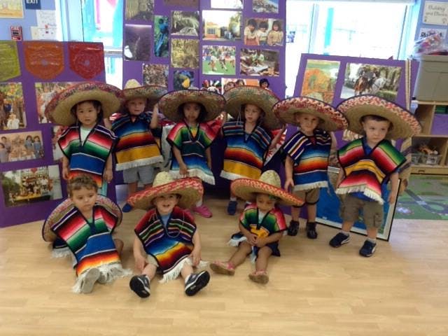 Group of children wearing sombreros and colorful striped ponchos