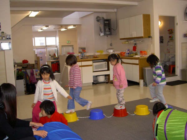 Children playing on colorful stepping stones in a room