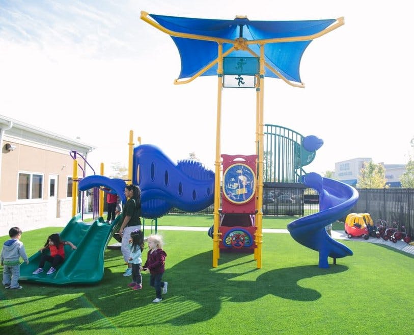 Children and adults on a playground with slides and play structures