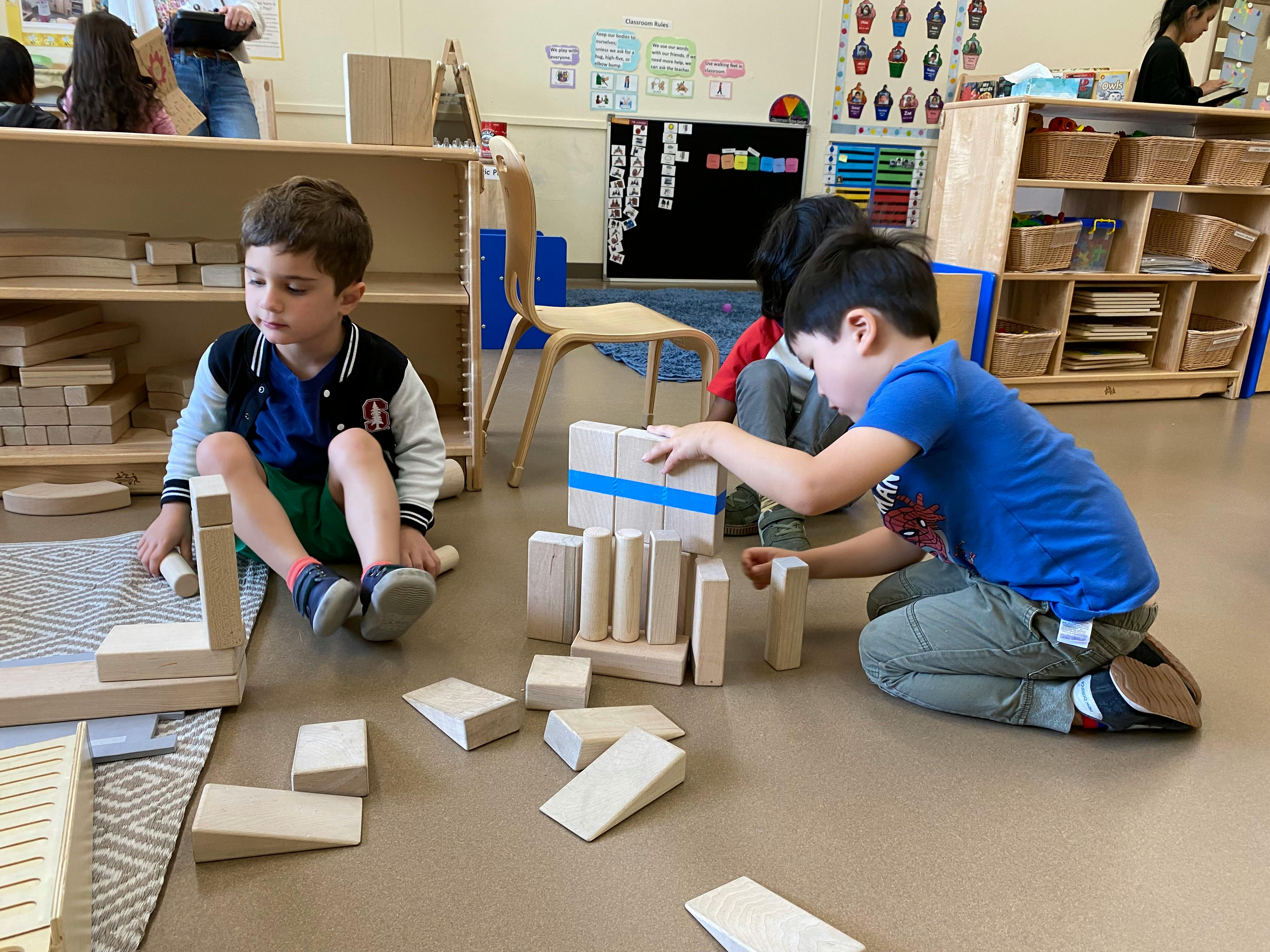 Children playing with wooden blocks in a classroom