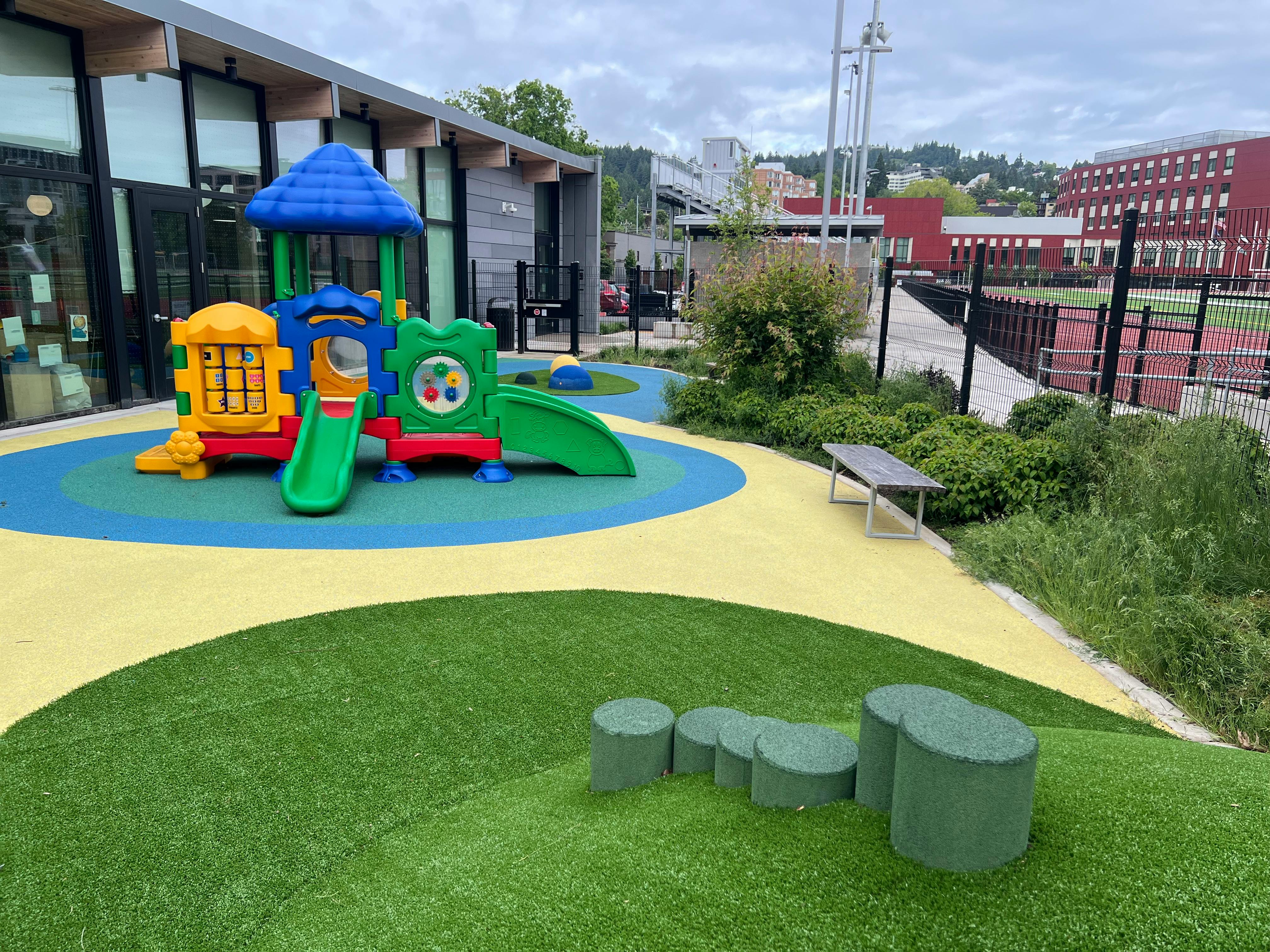 Playground with colorful play structure and green artificial turf