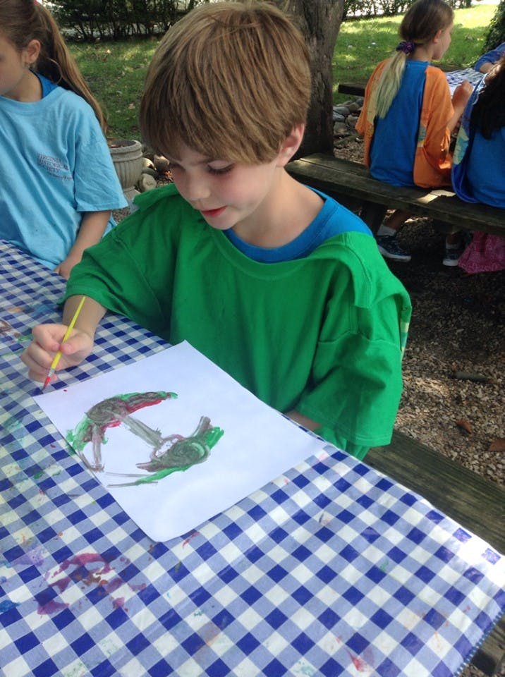 Child painting on paper at a table