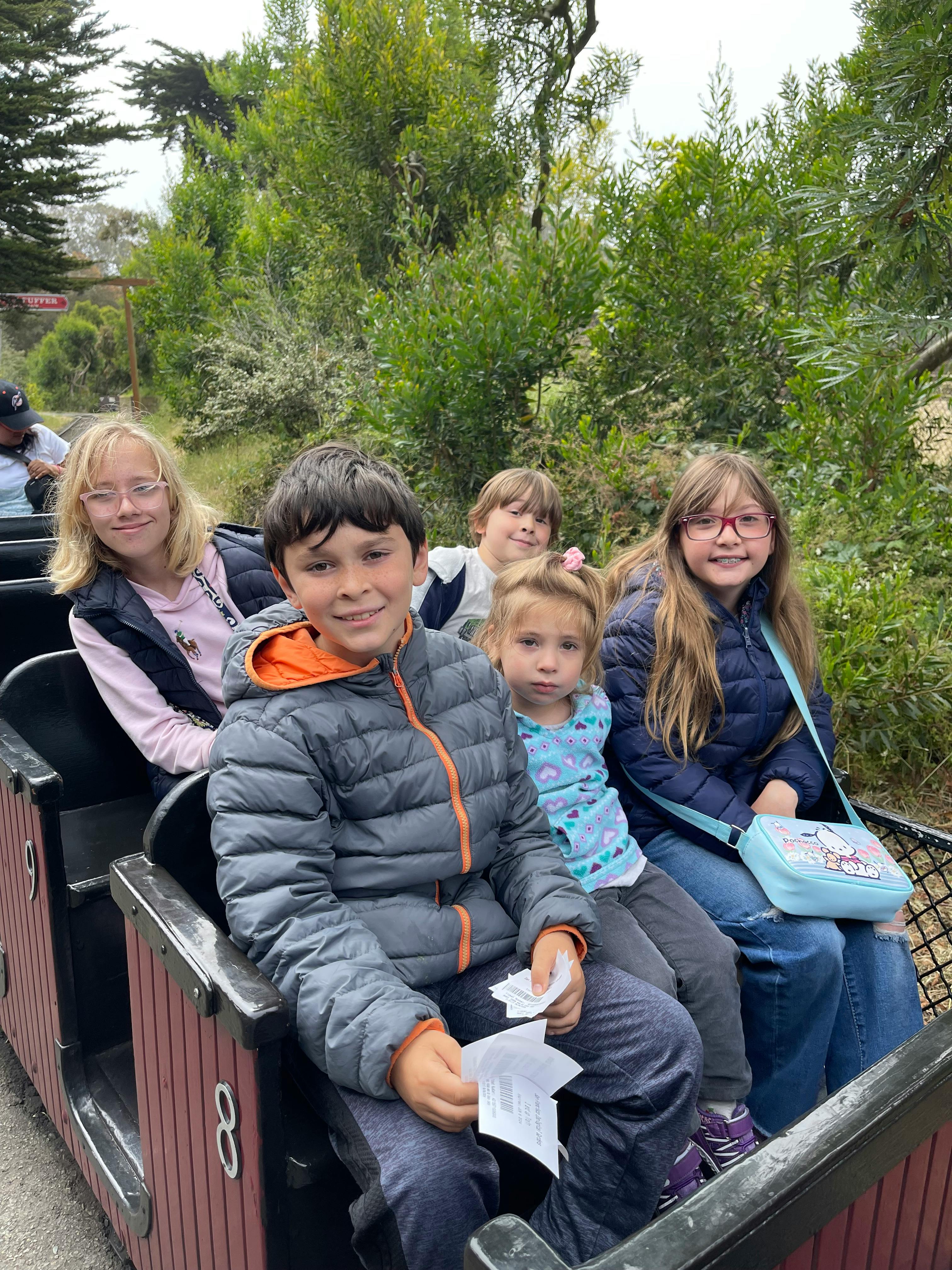 Group of children and teens riding in a train car