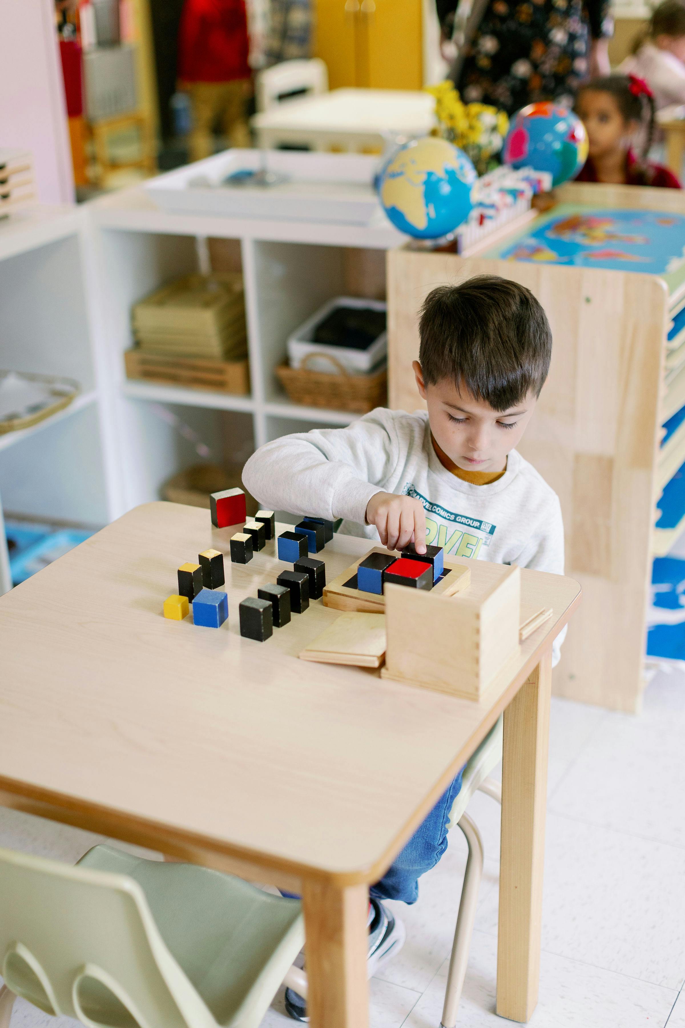 Child playing with colorful blocks at a table