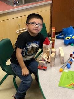 Child sitting at a table with wooden blocks