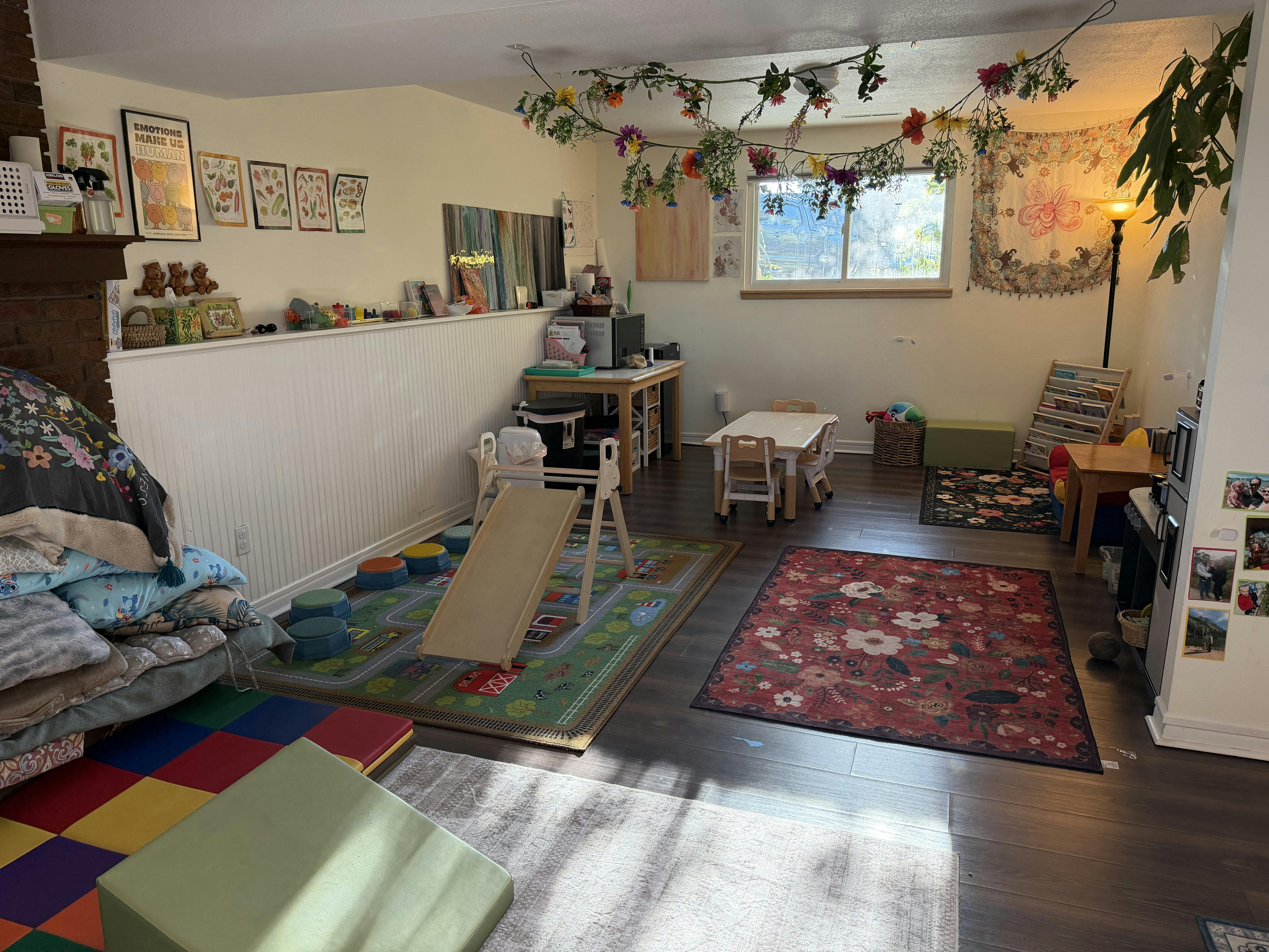 Playroom with area rugs, a small wooden slide, and kid-sized furniture