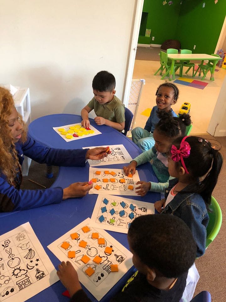 Adult and children at a table with learning activities