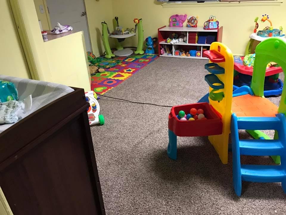Playroom with colorful play equipment and a patterned rug